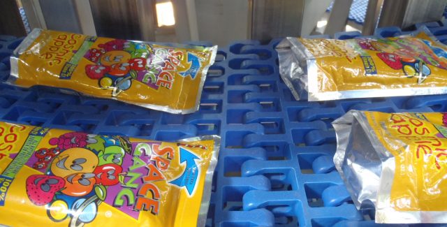 Four Juice Pouches on the Blue Modular Plastic Belt of an IJ White Pouch Processing System