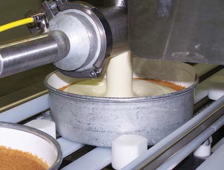 Batter being poured into the crust of a pan at the Cheesecake Factory in North Carolina where IJ White Spiral Coolers are in operation