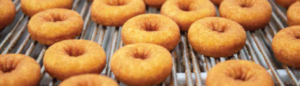 Klosterman Baking Donuts that have been cooled on an IJ White Spiral Cooler